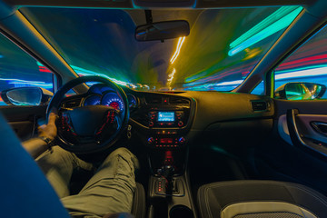 Night road view from inside car natural light street and other cars is motion blurred