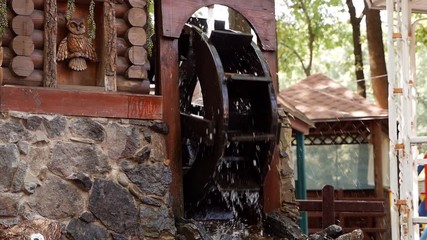 A wooden wheel produces energy using the power of water an old traditional mechanism. Wooden ring rotates with the power of water