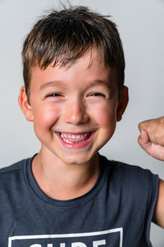 Portrait of strong boy, laughing, white background