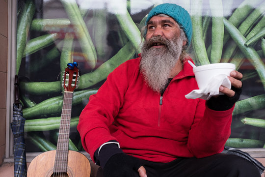 Man with guitar holding cup