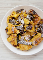Homemade german Kaiserschmarrn pancake with apple sauce on a white wooden surface, top view. Flat lay, overhead, from above. Closeup.