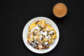 Homemade german Kaiserschmarrn pancake with apple sauce on a black background, top view. Flat lay,...