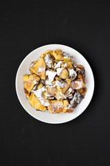 Homemade german Kaiserschmarrn pancake on a black background, top view. Flat lay, overhead, from above. Closeup.