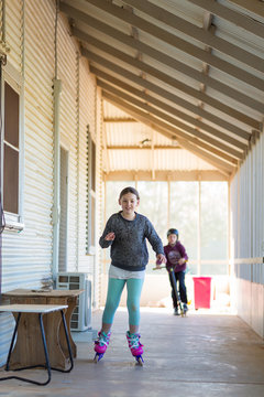 Kids skating on verandah at home