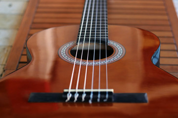 Fototapeta premium Music Concept: Brown acoustic guitar on a wooden background.
