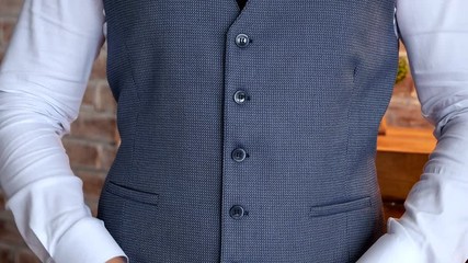 Successful young man fastens buttons on a jacket on a wedding day. Wedding Preparation Celebration