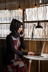 portrait of a young woman working on laptop