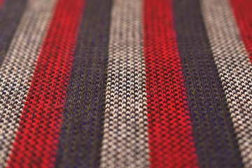 Red, gray and white striped wool cloth. Flat texture detail.