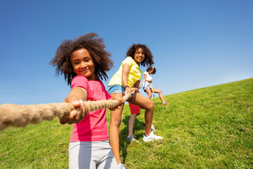 Girl portrait pulling rope in competitive fun game