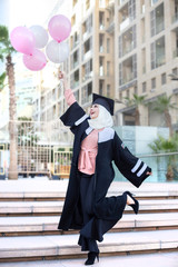 young woman in the city with Hijab celebrate of her graduation 
