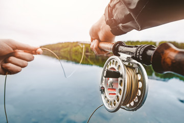 Coil of fly fishing rope, man hands holding rod