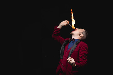 Fire show, fakir magician swallows burn and puts out tongue in mouth © Parilov