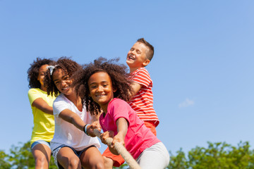 Boys and girls play pull cord in competitive game