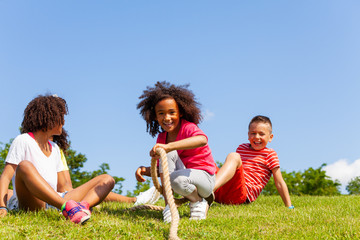 Group of kids fall pulling rope - competition game