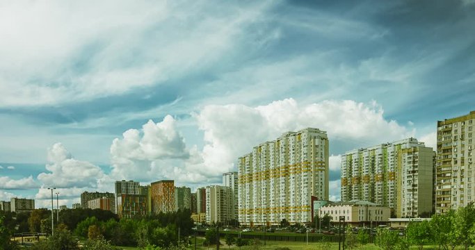 Cumulus clouds motion over the sleeping area in Moscow over the high-rise apartment buildings in the prospectus