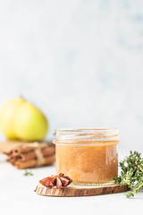 Spicy pear jam in glass jar, fresh pears, spices (cinnamon and anise) and thyme.