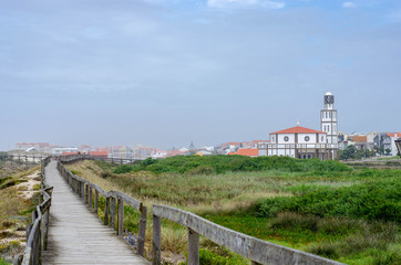 Fototapeta na wymiar Wooden boardwalk path to the atlantic ocean beach in Costa Nova do prado, Portugal