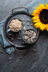 Fototapeta na wymiar Healthy snack, a heap of whole and peeled sunflower seeds in jars
