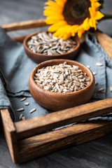 Healthy snack, a heap of whole and peeled sunflower seeds in bowls