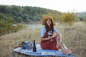Young woman with a glass of wine at sunset.
