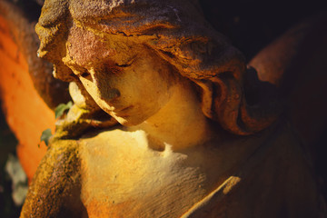 Beautiful angel in the sunlight. Antique statue.