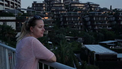 Young tourist, on the observation deck examines the city against the background of an island hotel, in Budva, Montenegro