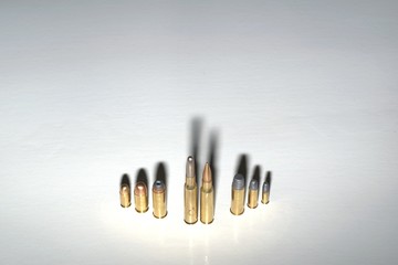 Crime family concept. Several bullets on a white surface with dramatic shadows.