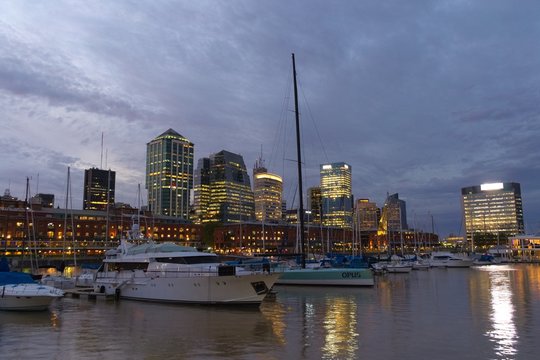 Several yachts anchored in Puerto Madero, in the city of Buenos Aires, at dusk.