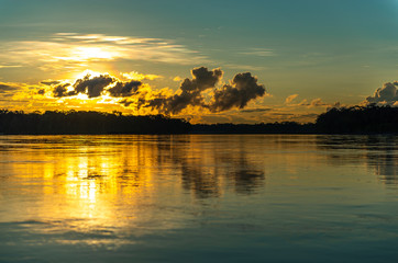 Sunset along the Pastaza river in the Amazon Rainforest with a unsharp foreground, Ecuador.
