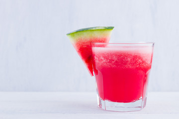 Watermelon drink in glasses with slices of watermelon. Watermelon smoothies on white background. Summer healthy drink for vegetarian. Copy space