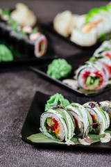 Various kinds of sushi served on black stone