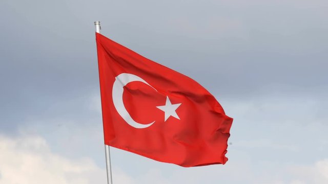 Turkish National flag waves in the wind against the sky