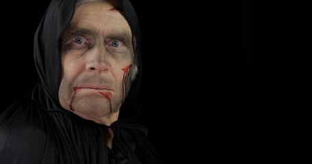 Old executioner Halloween makeup and costume. Elderly man with blood on his face