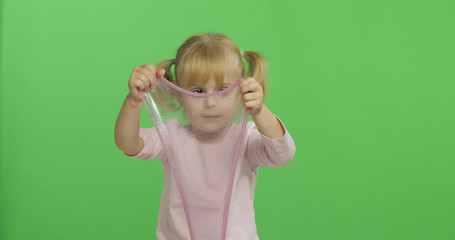 Kid playing with hand made toy slime. Child having fun making pink slime