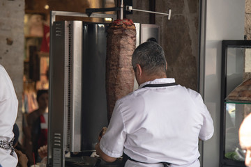 The chef who cuts doner kebab. Back of cook