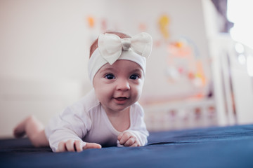 happy beautiful baby girl in white body suit