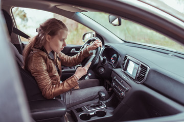 woman driving car, selects navigation on phone s display screen, turns voice assistant, searches...