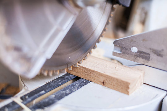 Kapps&auml;ge Holzzuschnitt mit S&auml;ge mit S&auml;geblatt Holzst&uuml;ck in Werkstatt Holz kappen, k&uuml;rzen