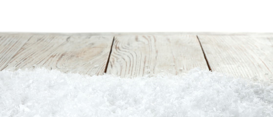 Heap of snow on wooden table against white background. Christmas season