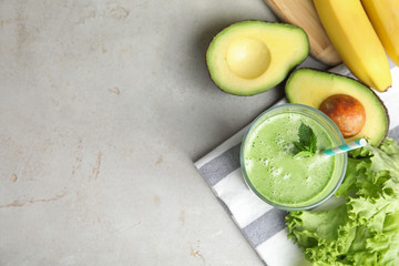 Flat lay composition with tasty avocado smoothie on grey table. Space for text