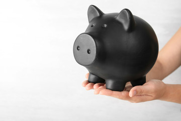 Woman holding piggy bank on white background, closeup view