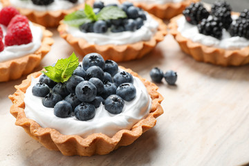 Different berry tarts on table, closeup. Delicious pastries
