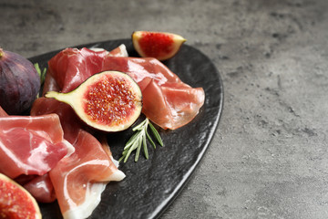 Delicious ripe figs and prosciutto served on table