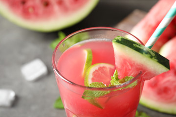 Glass of tasty refreshing drink with watermelon on grey table, closeup