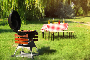Modern barbecue grill with tasty food in park - obrazy, fototapety, plakaty