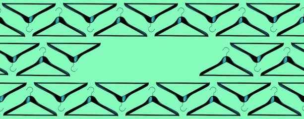 Fashion frame made of clothes hanger pattern on neo mint background.