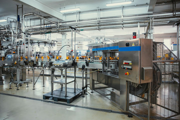 Plastic bottles with juice on automated conveyor line or belt in modern beverage plant or factory...