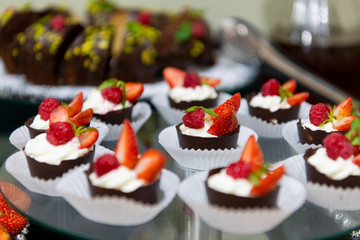 Fruit tart with raspberries and cream, cakes and sweetness on holiday background. Delicious dessert and candy bar.