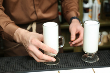 Barista preparing tasty coffee drink at counter, closeup