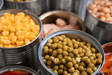 Open tin cans with conserved products, closeup